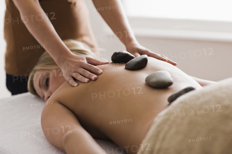 Caucasian woman receiving hot stone massage