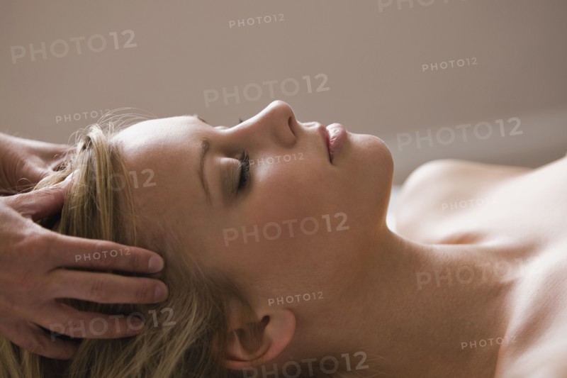 Caucasian woman receiving head massage