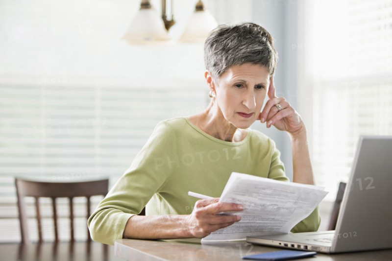 Senior woman paying bills on laptop