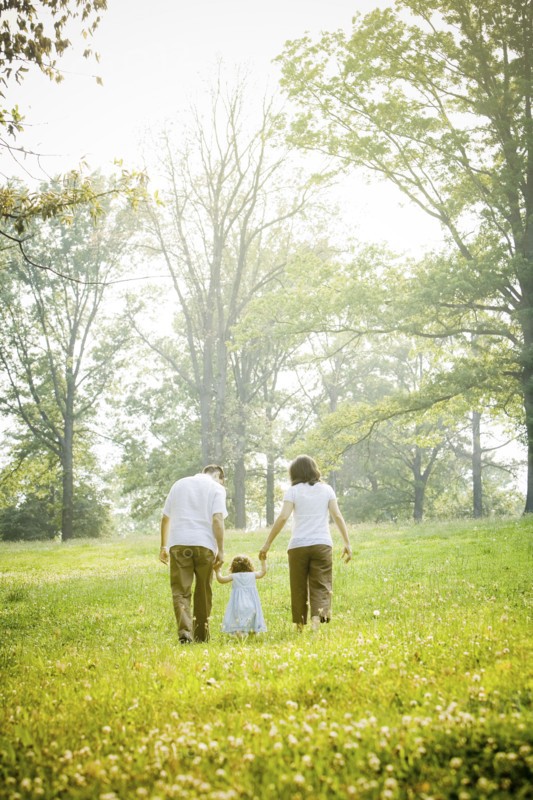 Parents walking with daughter in field