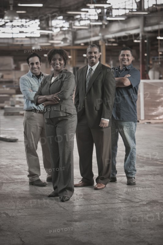 Business people and workers standing in warehouse