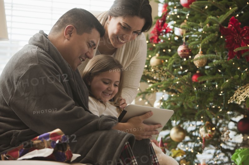 Family looking at digital tablet on Christmas morning