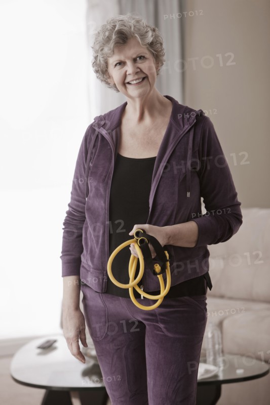 Caucasian woman holding exercise bands in living room