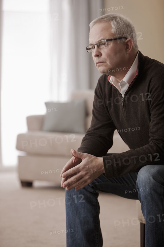 Serious Caucasian man sitting in living room