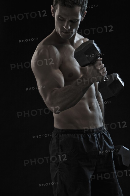 Caucasian man exercising with hand weights