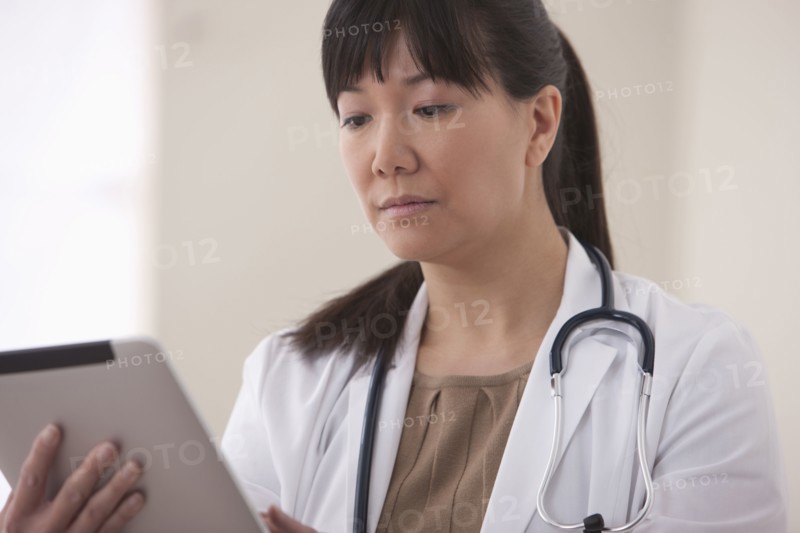 Asian doctor using digital tablet