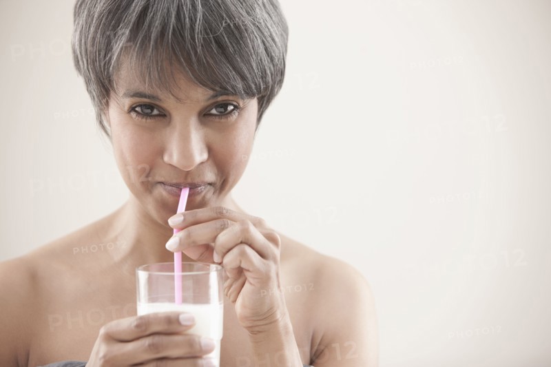 Mixed race woman drinking milk