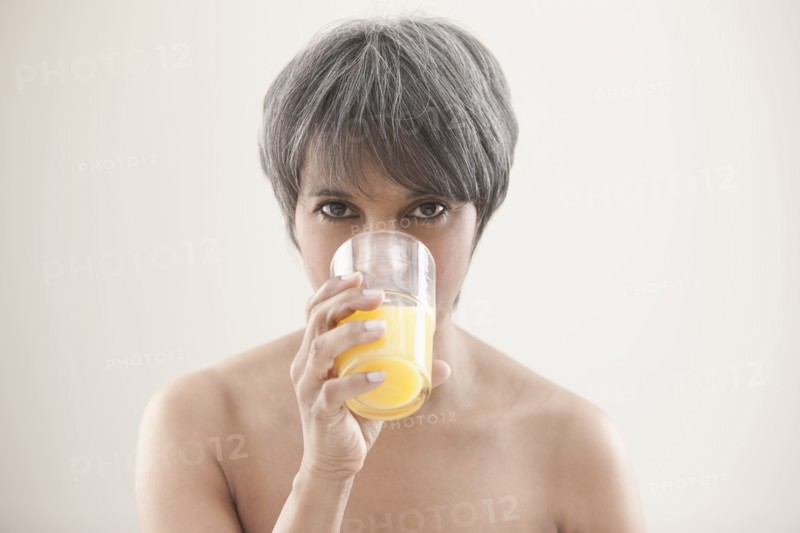 Mixed race woman drinking orange juice