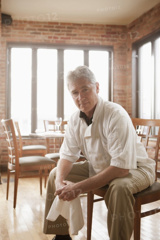 Caucasian chef sitting in restaurant