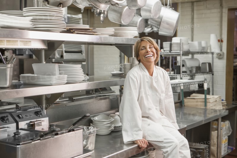 Caucasian chef sitting in commercial kitchen