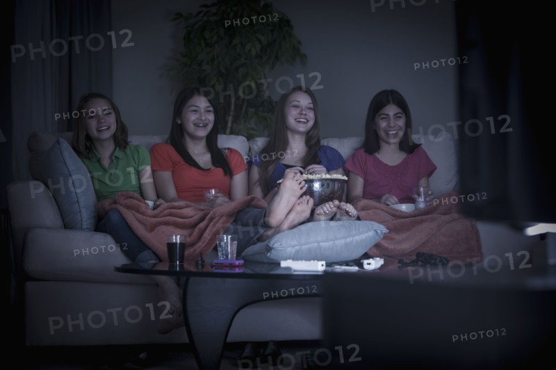 Friends eating popcorn and watching a movie