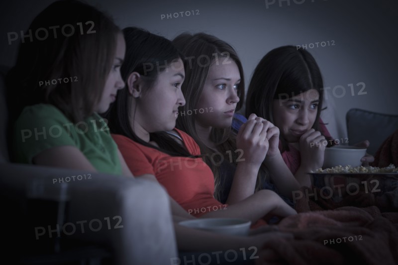 Friends eating popcorn and watching a movie