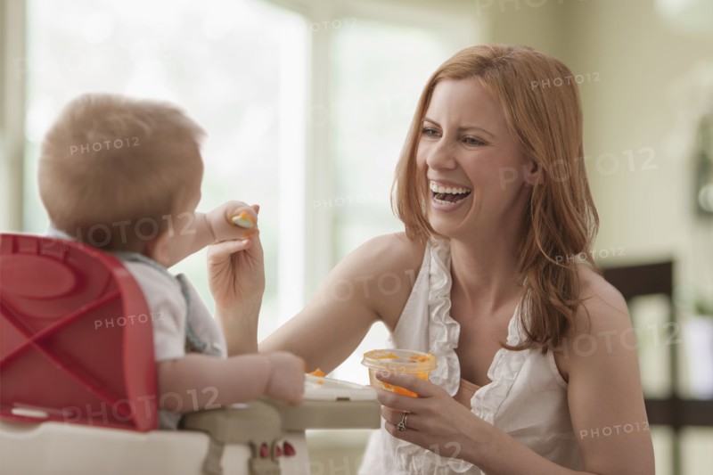 Caucasian mother feeding son