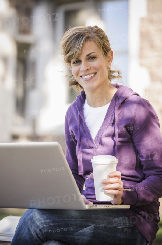 Caucasian student using laptop on campus