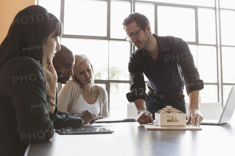 Business people examining model in meeting