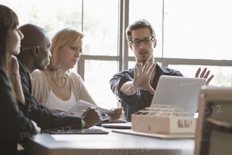Business people using laptop in meeting