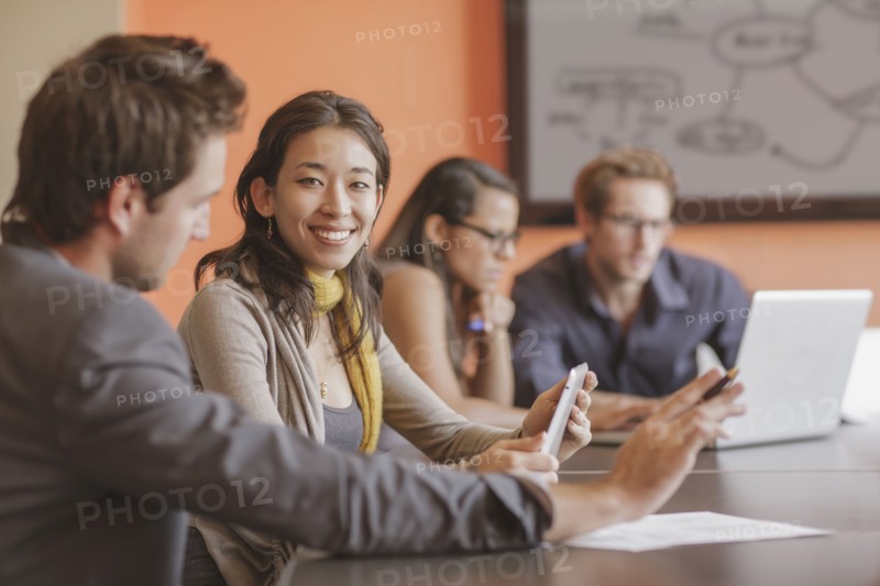 Mixed race businesswoman smiling in meeting