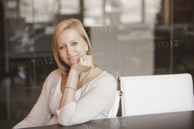 Caucasian businesswoman smiling at desk