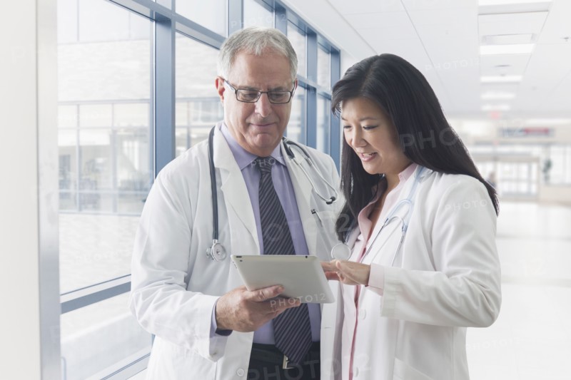 Doctors using tablet computer in hospital