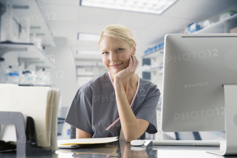 Caucasian nurse working at computer in hospital
