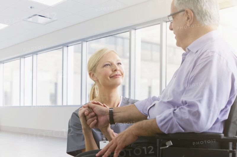 Caucasian nurse talking to patient in hospital
