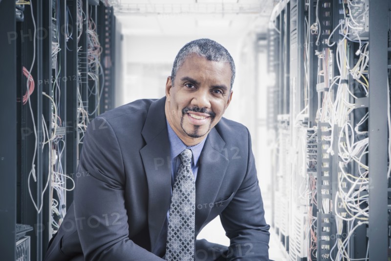 Mixed race businessman sitting in server room