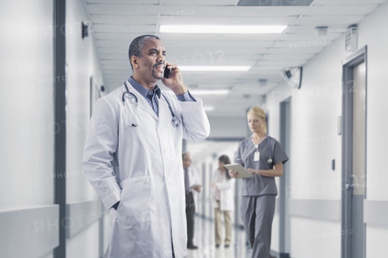Mixed race doctor talking on cell phone in hospital