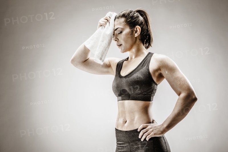 Caucasian woman wiping sweat from forehead