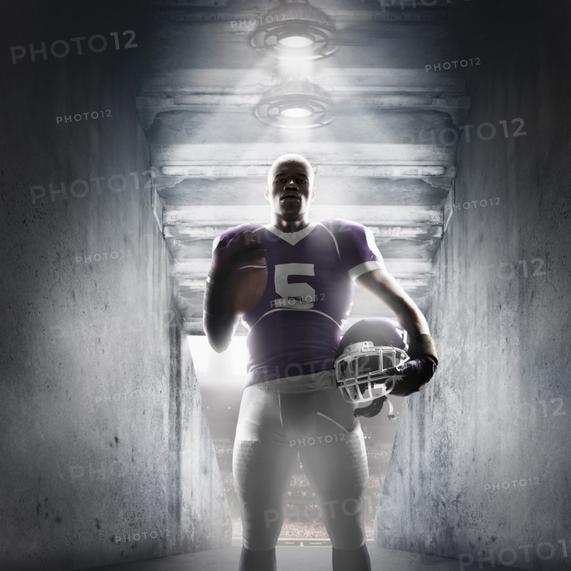 African American football player standing in hallway