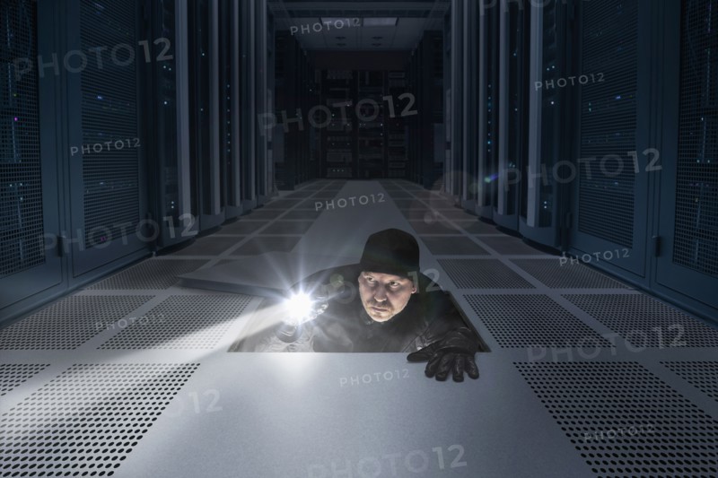 Caucasian man shining light in air vent