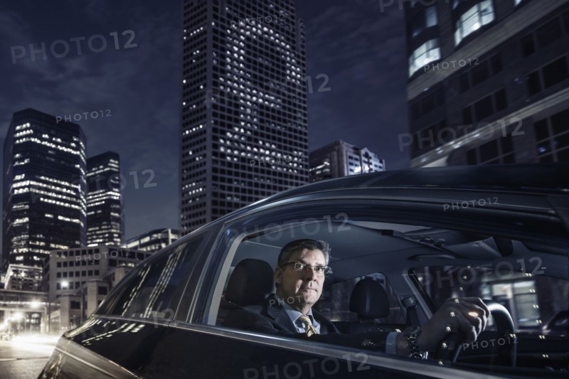 Caucasian businessman driving on city street