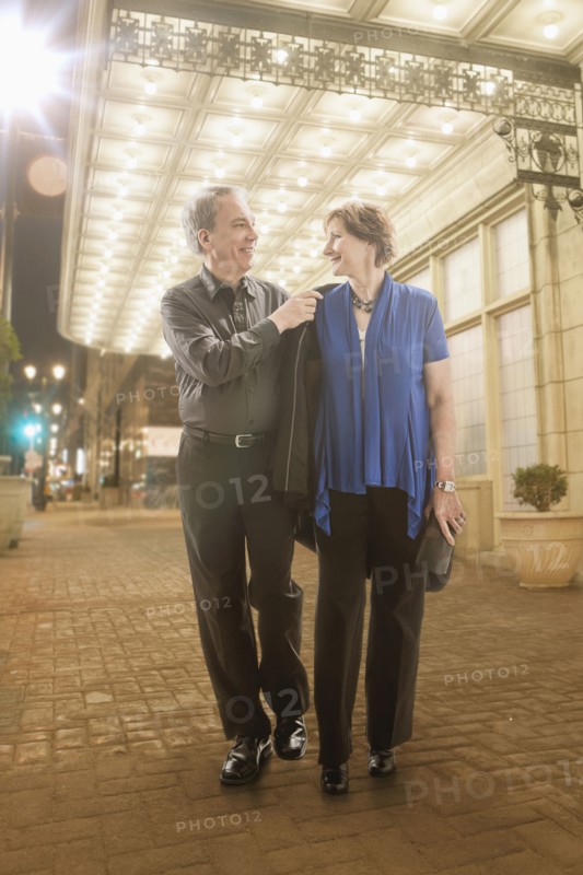 Caucasian couple walking on city street