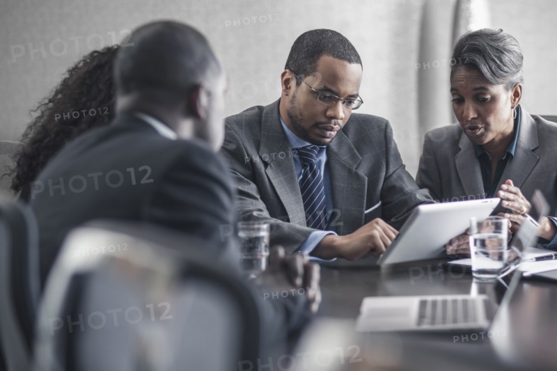 Business people using digital tablet in meeting