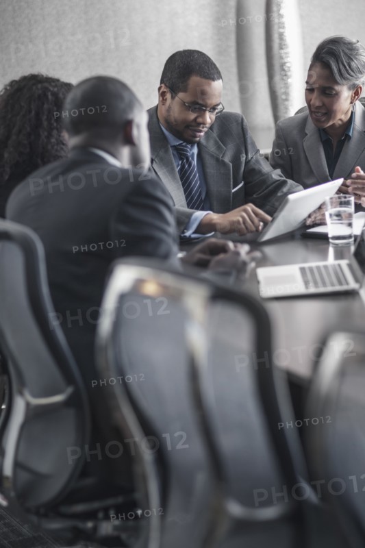 Business people using digital tablet in meeting