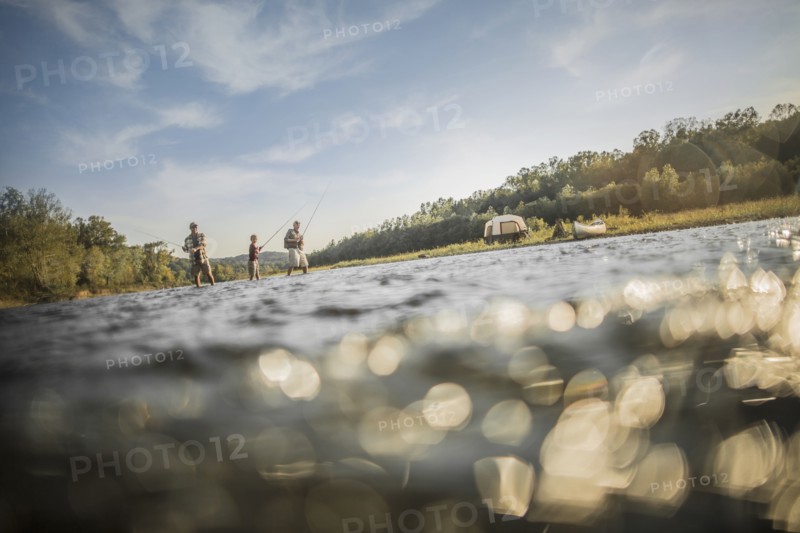 Three generations of Caucasian men fishing in river