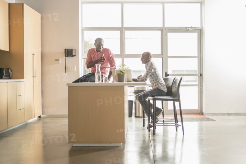 Business people talking in office kitchen