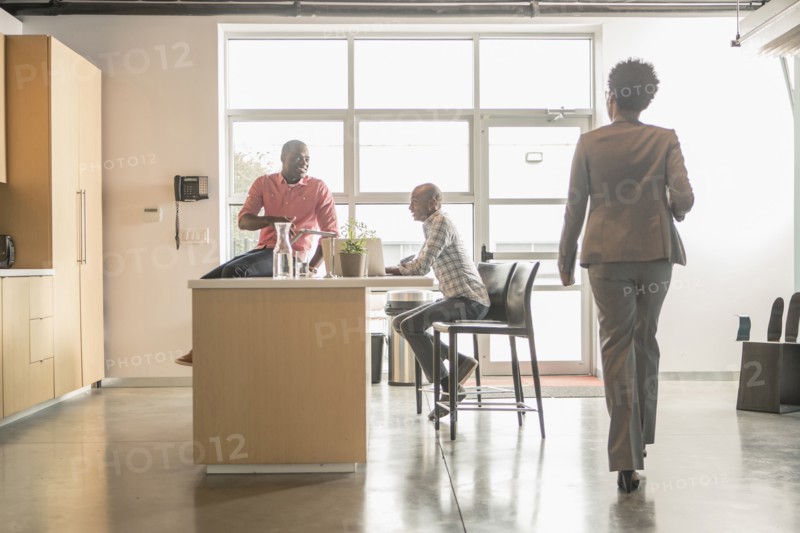 Business people relaxing in office kitchen
