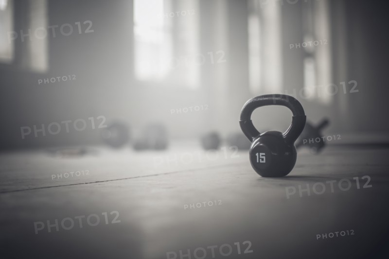 Close up of kettlebell weights on floor of dark gym