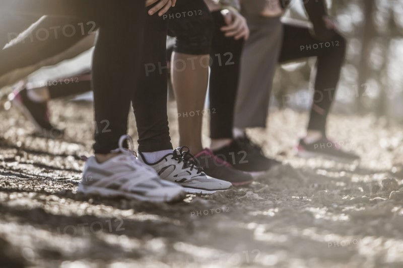 Close up of runners stretching in a row
