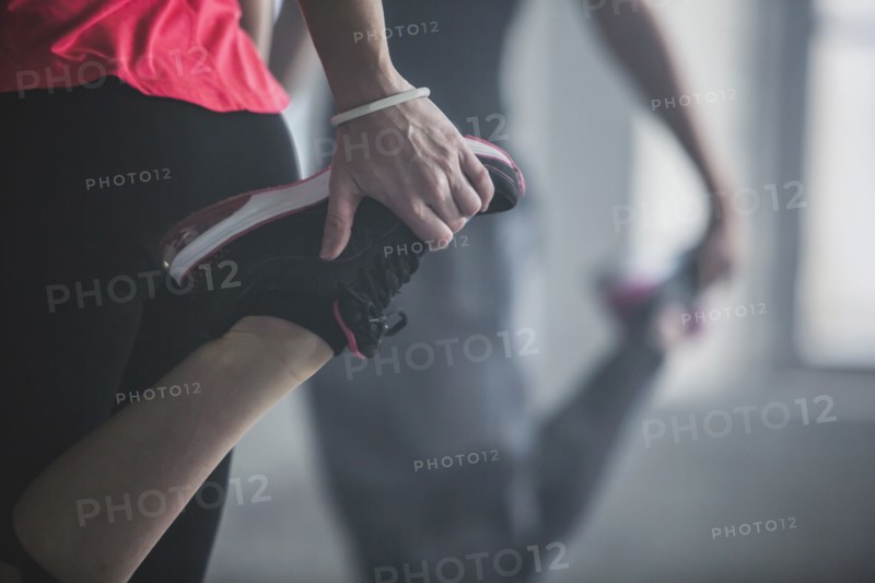 Athletes stretching legs in gym