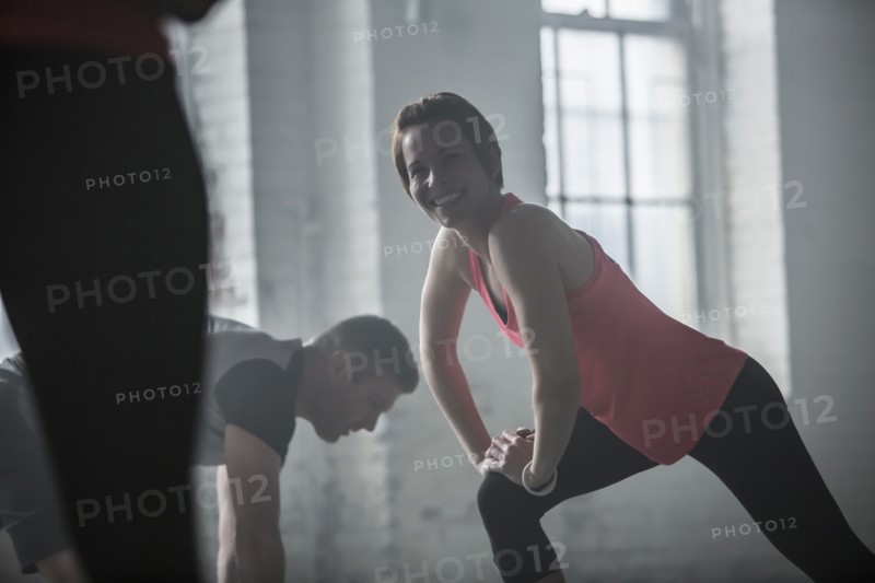 Athletes stretching legs in gym