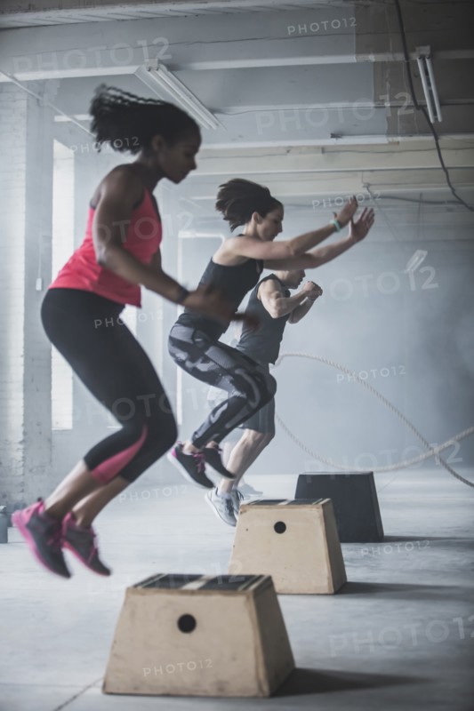 Athletes jumping on platforms in gym