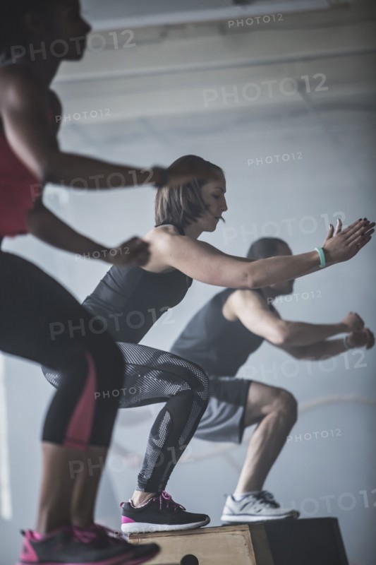 Athletes jumping on platforms in gym
