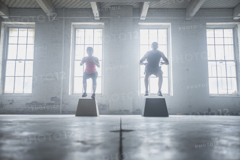 Silhouette of athletes jumping on platforms