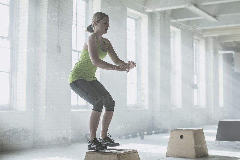 Athlete jumping on platform in gym