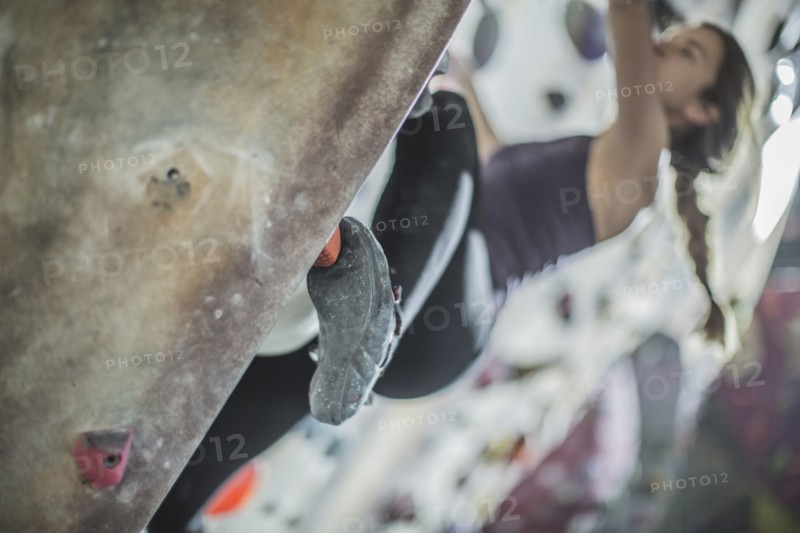 Close up of athlete climbing rock wall in gym