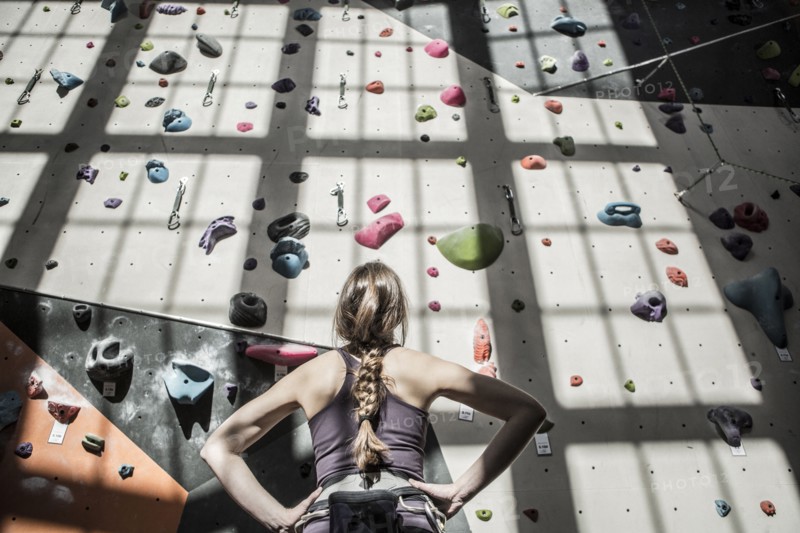 Athlete examining rock wall in gym