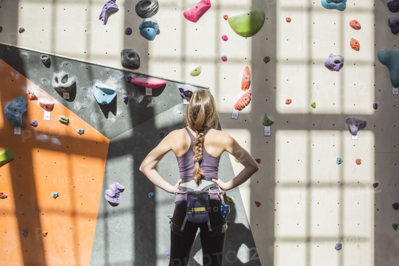 Athlete examining rock wall in gym