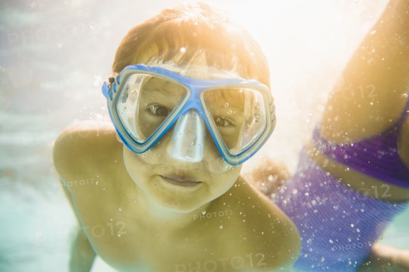 Caucasian boy swimming underwater in swimming pool
