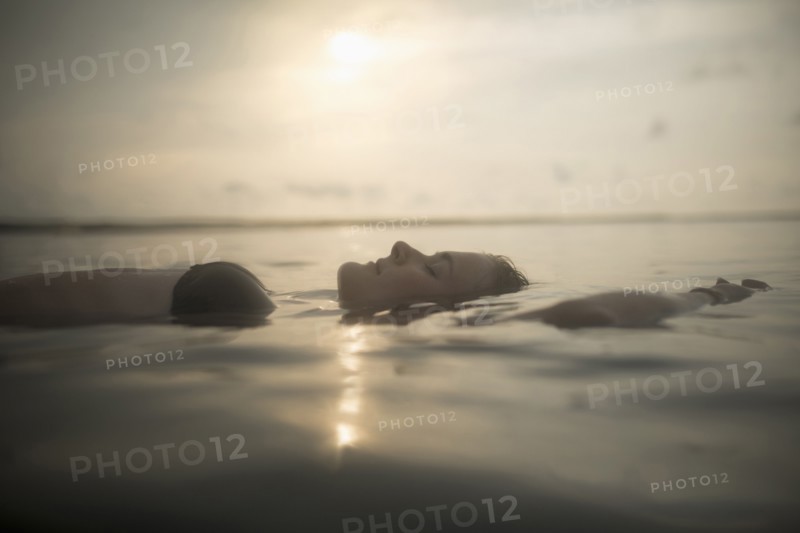 Caucasian woman floating in still lake